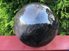 Load image into Gallery viewer, SOLD OUT ~ Reserved for Angela ~ Payment 8 of 20 ~ Large Clear Quartz Tourmaline Crystal Ball ~ 6&quot; Wide ~ 14 Lb. 5 oz ~ Thick Black Hairs